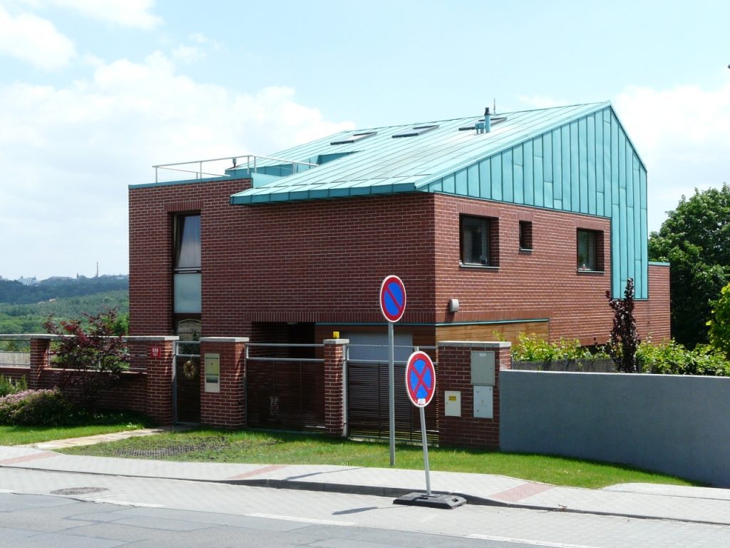 Novostavba rodinného domu s dokončenou konstrukcí střechy a oplechováním